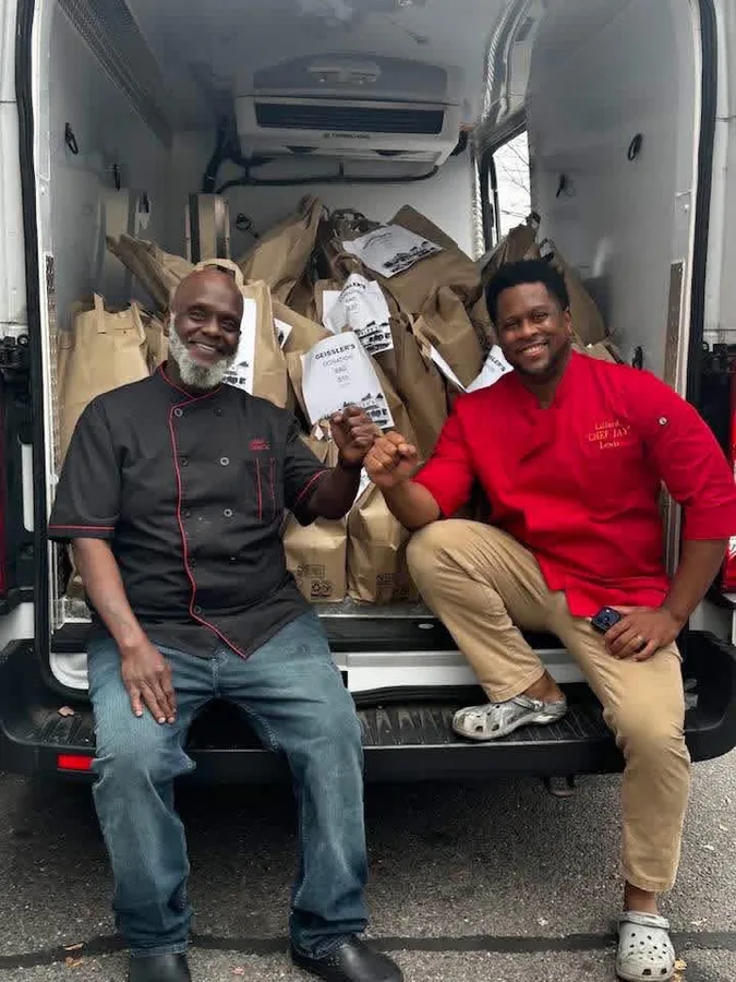 Chef Jay Lewis and Chef Derrick in front of donated goods